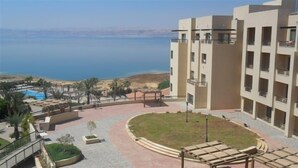 A modern building with a pool and a view of the sea. - Dead Sea Spa Hotel (Sweimeh)