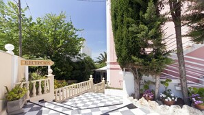 A reception area with a checkered floor, a sign reading "RECEPCIÓN", and a white building with a pink facade. - Cala Bona & Mar Blava Hotels (Ciutadella de Menorca)