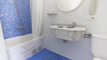 Een badkamer met een bad, een wastafel en een toilet.