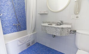 Une salle de bain avec une baignoire, un lavabo et des toilettes.