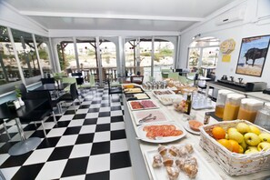 A buffet setup with various food items and a checkered floor. - Cala Bona & Mar Blava Hotels (Ciutadella de Menorca)