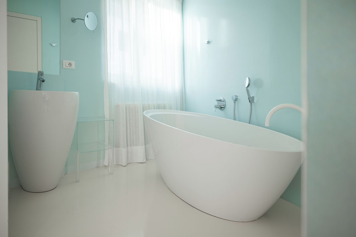 Ein modernes Badezimmer mit einer freistehenden Badewanne, einem Waschtisch mit Spiegel und einer Duschkabine.
