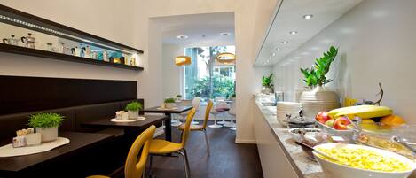 A modern dining area with a buffet, seating, and a view of the outdoors.