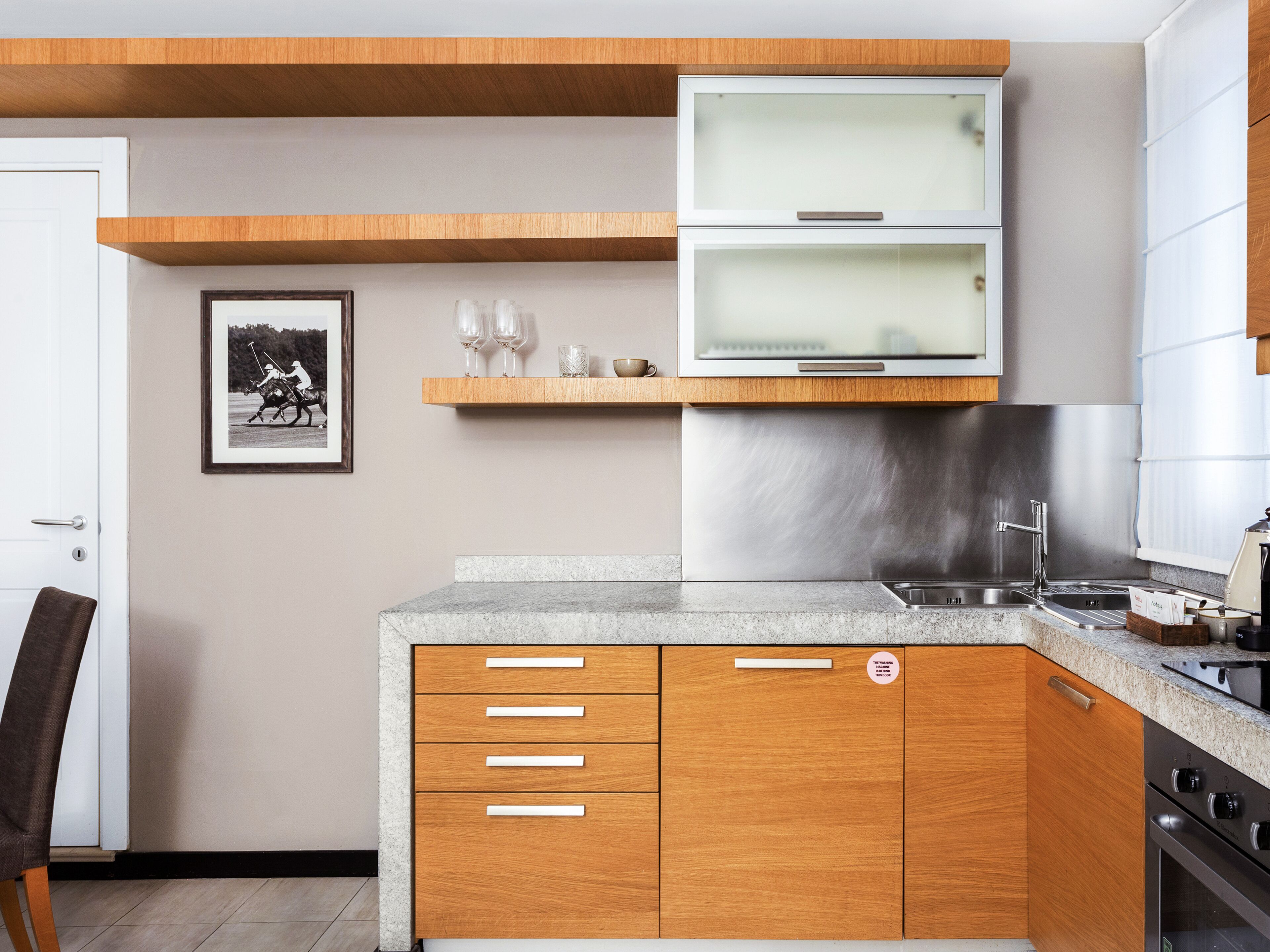 A modern kitchen with wooden cabinets, a stainless steel range, and a built-in oven.