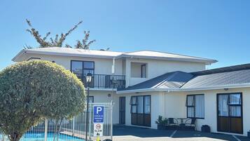 A two-story motel with a pool, check-in parking, and a balcony.