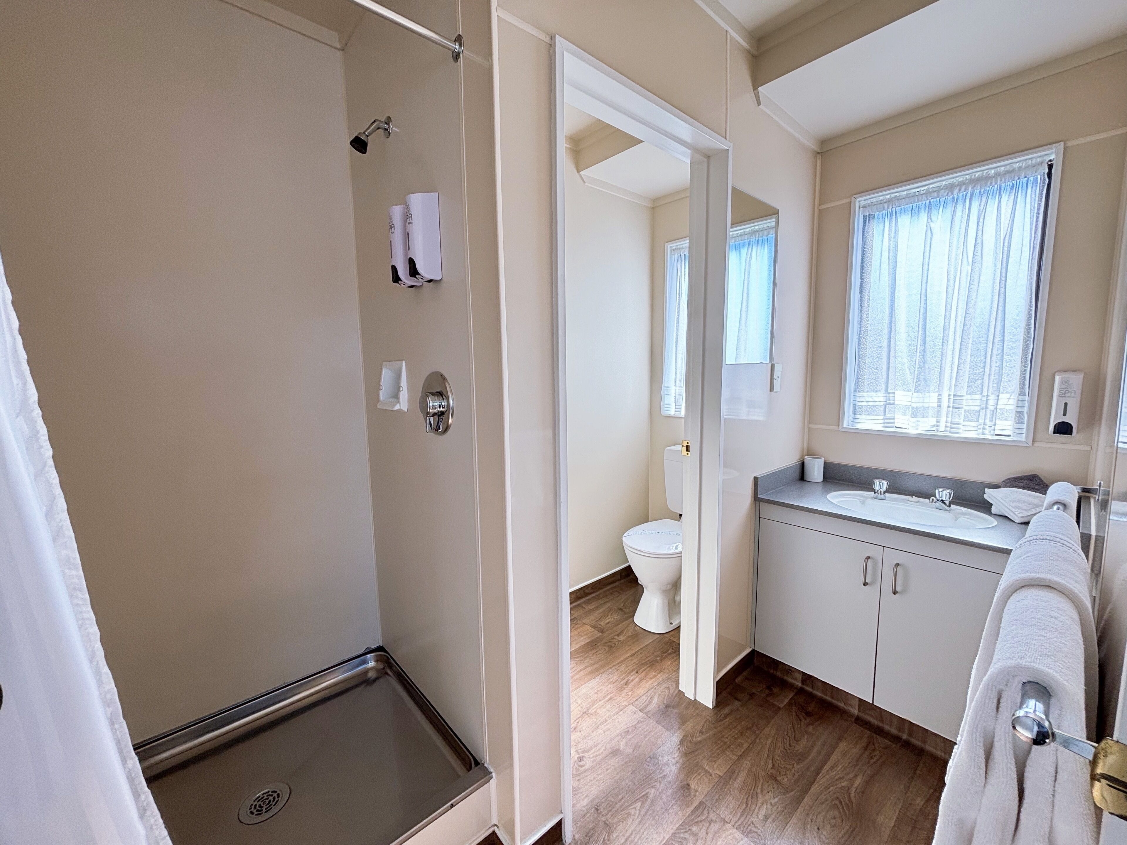 Un baño moderno con ducha, inodoro y lavamanos.