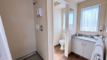 Un baño moderno con ducha, inodoro y lavamanos.