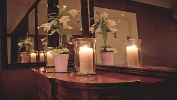 Una encimera de madera con velas y plantas en macetas.