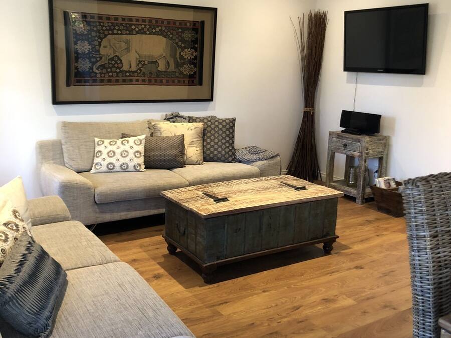 Ein Wohnzimmer mit einer Couch, einem Couchtisch und einem Fernseher.