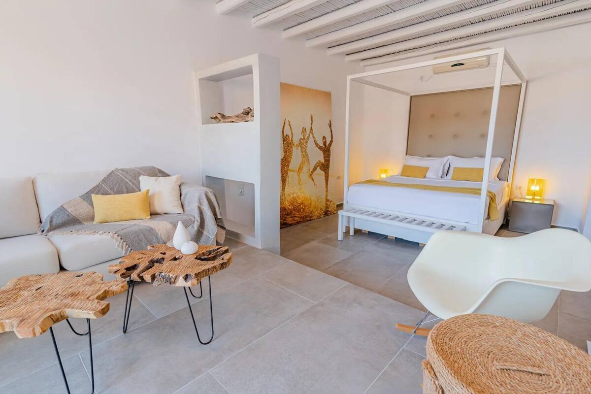 Une chambre moderne avec un lit à baldaquin, un canapé et une chaise blanche.
