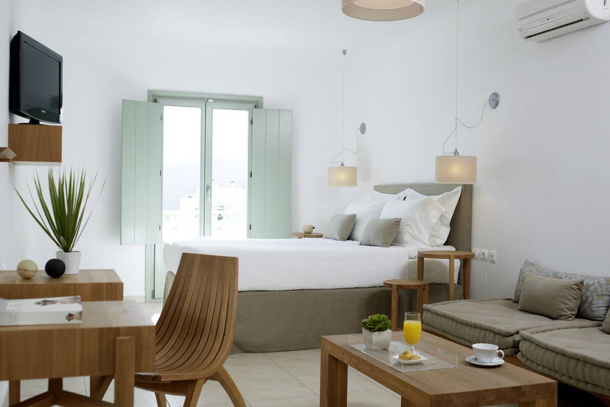 Une chambre d’hôtel moderne équipée d’un lit, d’un canapé, d’un bureau et d’une télévision.
