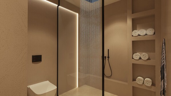 A modern bathroom with a glass shower enclosure, a white sink, and shelves with neatly rolled towels.