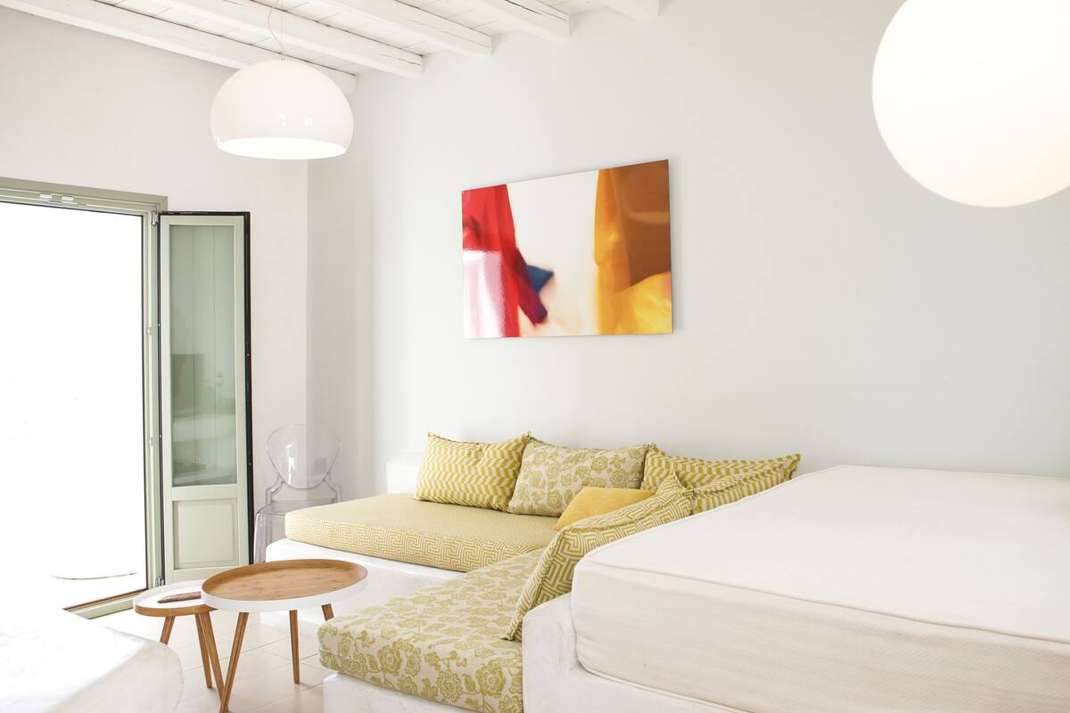 Une chambre moderne avec un lit, un canapé, une table et une porte en verre.