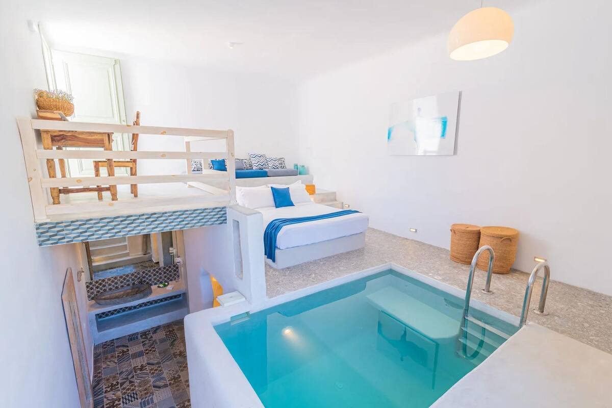 Une salle de bain moderne dotée d’une baignoire intégrée, d’un espace douche et d’un petit coin salon avec un banc.