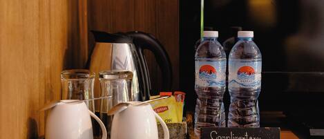 Un coin café équipé de deux bouilloires, de deux bouteilles d’eau et d’un moulin à café.