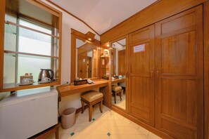 A compact kitchen with a refrigerator, a sink, and a wooden countertop.