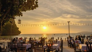 A seaside restaurant with tables and chairs arranged for dining, overlooking the ocean. - Sand Sea Resort (Krabi)