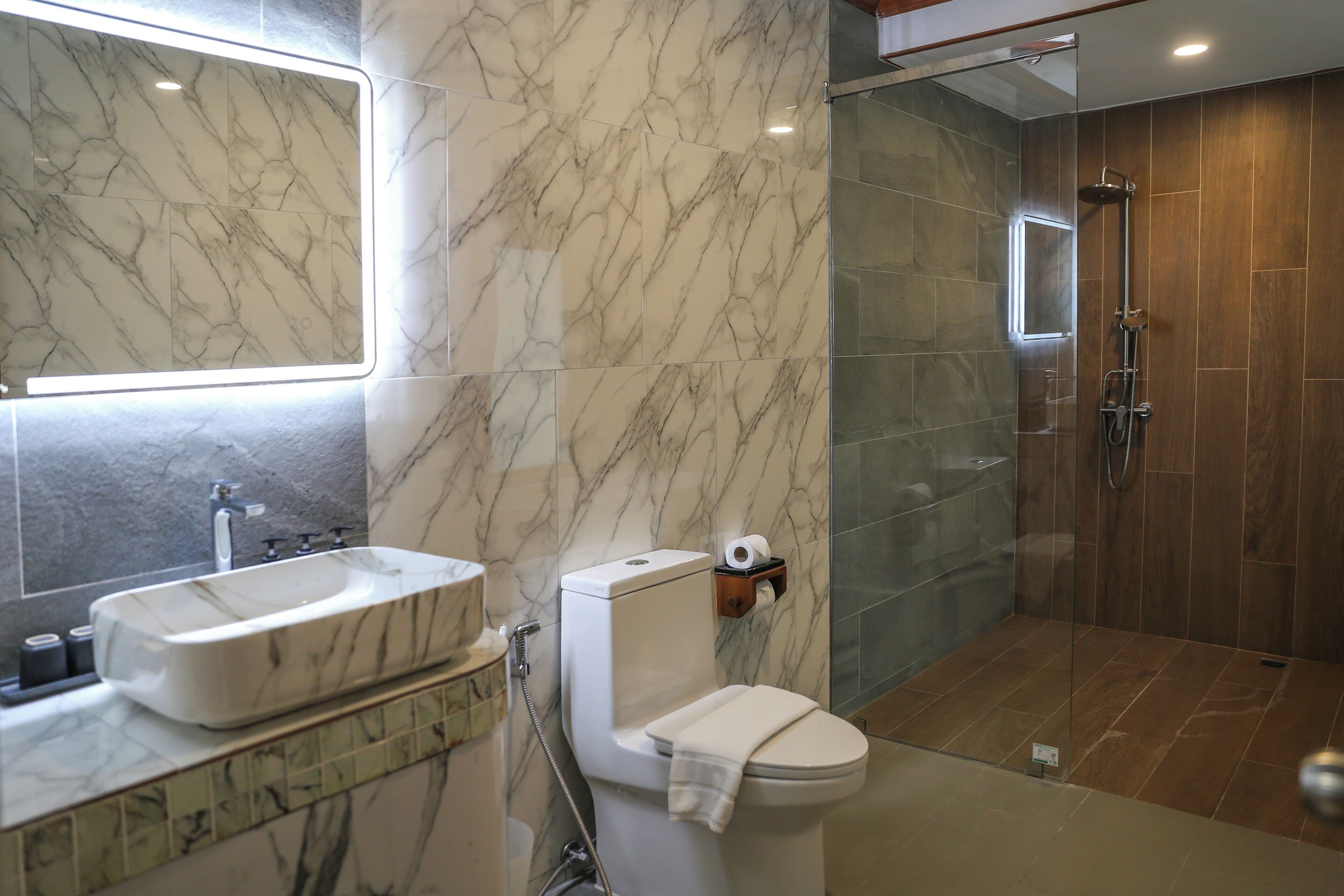 A bathroom with a marble sink, toilet, and shower.