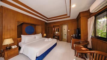 A hotel room with a large bed, a desk with a chair, a TV, and a window with curtains.