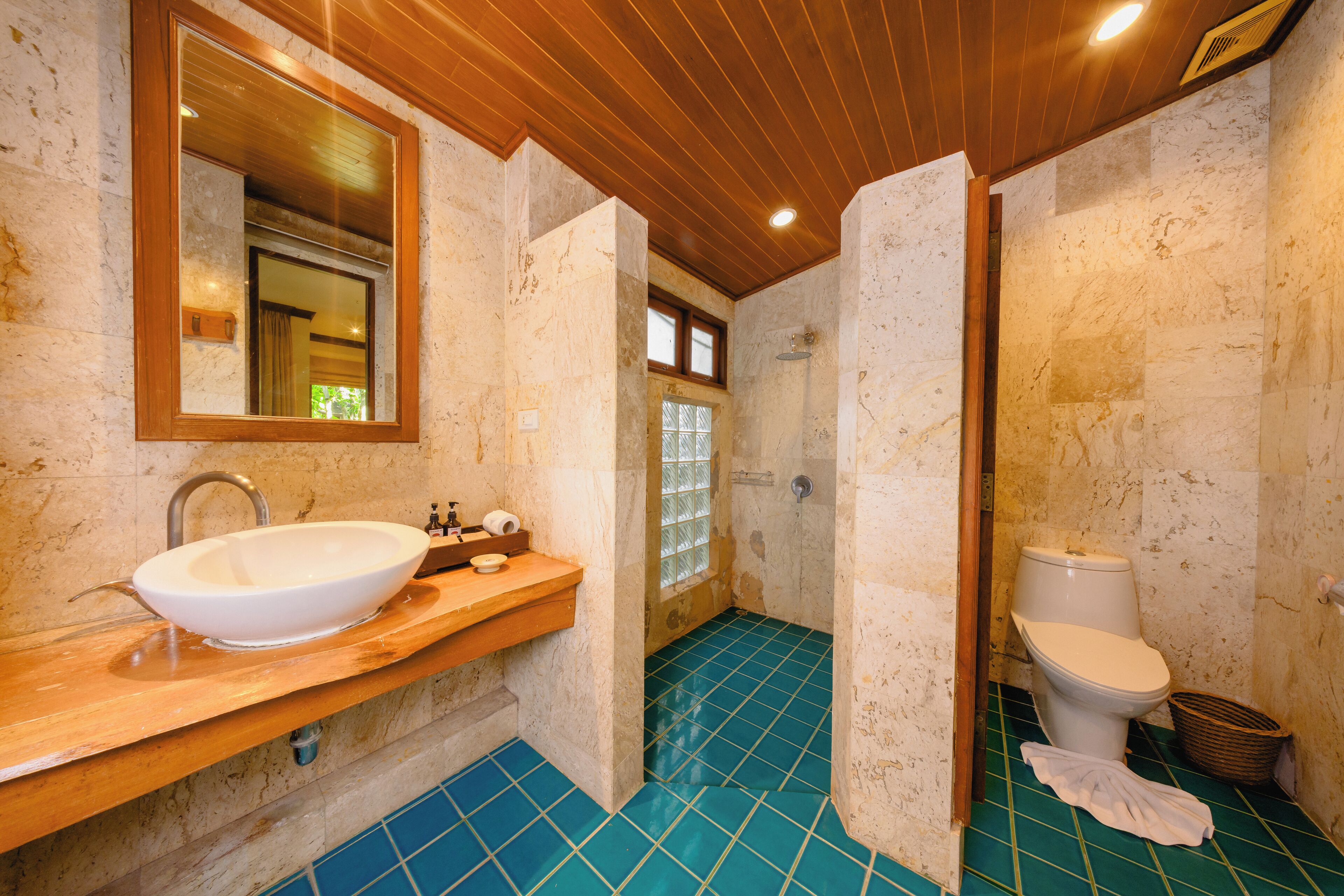 A bathroom with a white sink, wooden vanity, and a toilet.