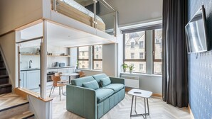 Un apartamento moderno con un altillo para el dormitorio, un comedor y una cocina.