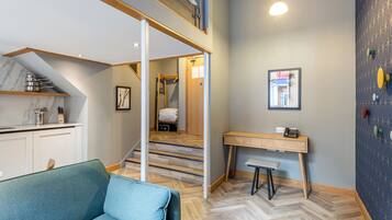 A modern interior with a sofa, a desk, and a staircase.