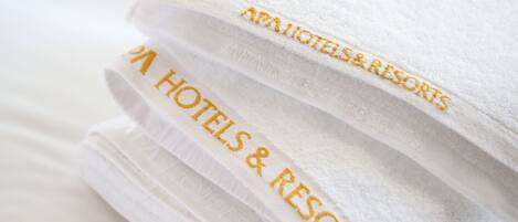 Ein Stapel weißer Handtücher mit eingesticktem Text: "AAA HOTELS & RESORTS".