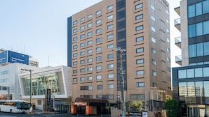A multi-story hotel with a modern design, featuring a prominent sign for the APA Hotel. - APA Hotel Tokyo Ojima (Tokyo)