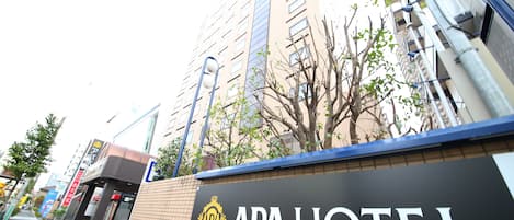 A hotel sign with the name "APA HOTEL" and a website address.
