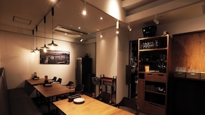 A dining area with wooden tables and chairs, a wall-mounted picture, and a wine rack. - APA Hotel Tokyo Ojima (Tokyo)