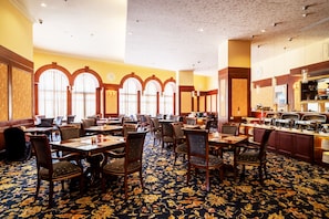 A hotel dining area with multiple tables and chairs, large windows with arched tops, and a buffet counter. - Capital Hotel Dazhi (Taipei)