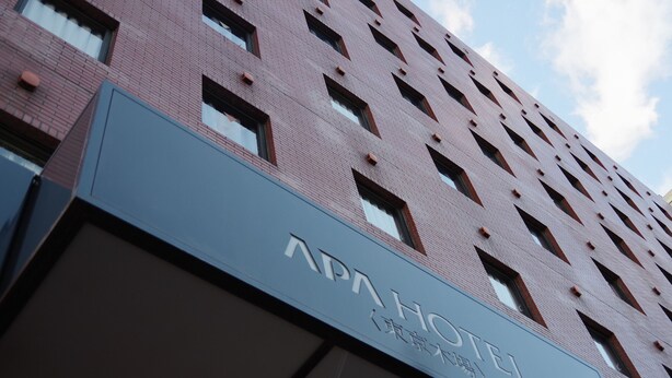 Een hotelschild met de naam 'APAHOTEL' en een symbool dat aangeeft dat het een hotel is.