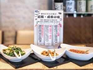 Three white bowls of food on a table with a menu stand in the background. - APA Hotel Keisei Narita Ekimae (Narita)