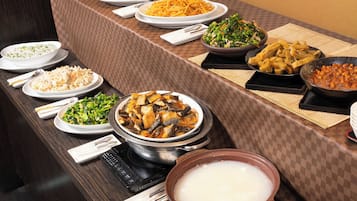 A buffet table with various dishes and a pot of soup.