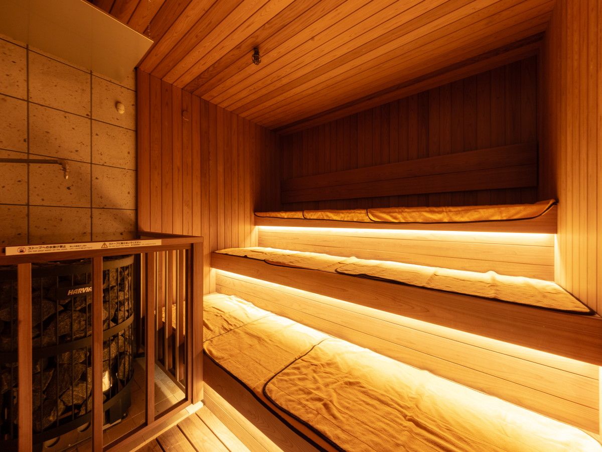 Una sauna con bancos de madera y puerta de cristal.