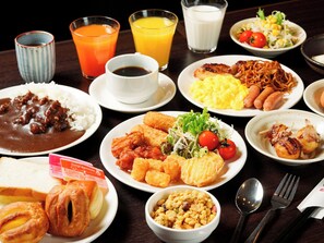 Una mesa con diversos platos que incluyen arroz, carne y verduras, además de bebidas y salsas.
