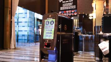 A currency exchange machine with a digital display and a sign indicating it's a money exchange service.