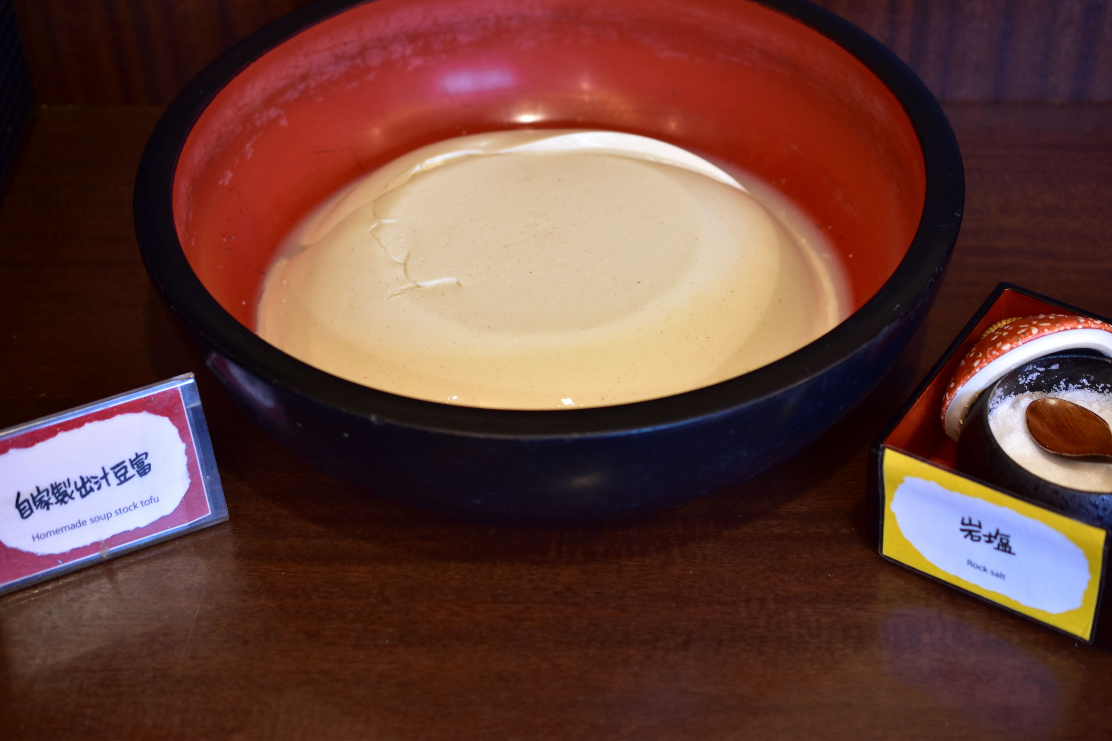 A bowl of soup with a label indicating it is homemade stock tofu.