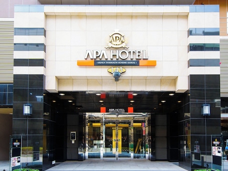 The exterior of APA Hotel Osaka Tanimaguchi 4-Chome Ekimae, featuring a modern facade with large glass windows and a prominent hotel sign.