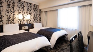 Habitación de hotel con dos camas, una mesita de noche con lámpara, aire acondicionado y ventana con cortinas.