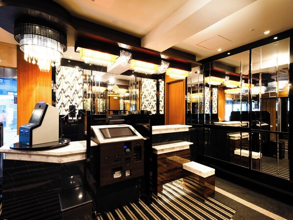 A modern hotel lobby with a self-service kiosk, marble counters, and a chandelier. - APA Hotel Osaka Tanimachi 4chome Ekimae Kita (Osaka)