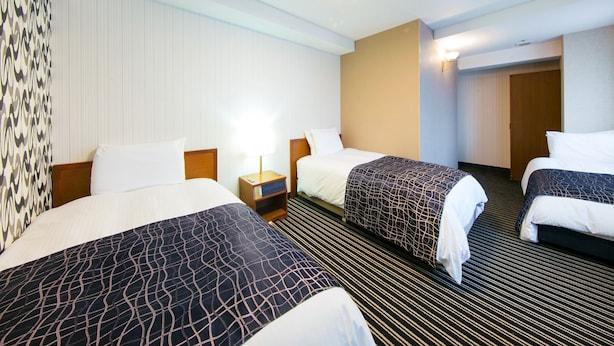 A hotel room with two beds, a nightstand, a lamp, and a door. - APA Hotel Osaka Tanimachi 4chome Ekimae Kita (Osaka)