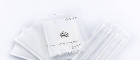 A stack of white cotton sheets with a logo and text on them.