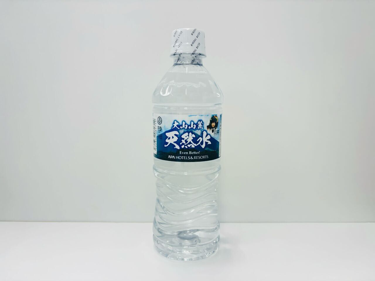 A clear plastic water bottle with a label that includes text and a graphic.