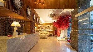 A hotel lobby with a reception desk, a sofa, a red decorative tree, and clocks on the wall. - The White Hotel 8A Thai Van Lung (Ho Chi Minh City)