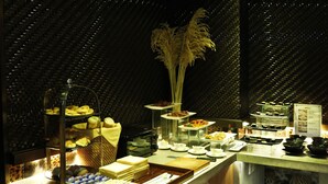 A buffet setup with various food items and a decorative plant. - The White Hotel 8A Thai Van Lung (Ho Chi Minh City)