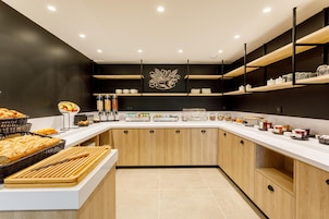 A modern kitchen with white countertops, wooden cabinets, and a decorative wall piece.