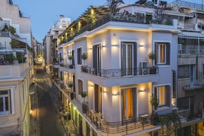 Un edifici de diverses plantes amb balcons, terrasses exteriors i un carrer estret.
