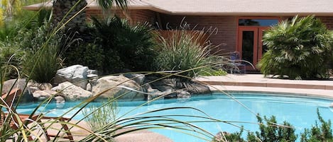 Een buitenzwembad en ligstoelen