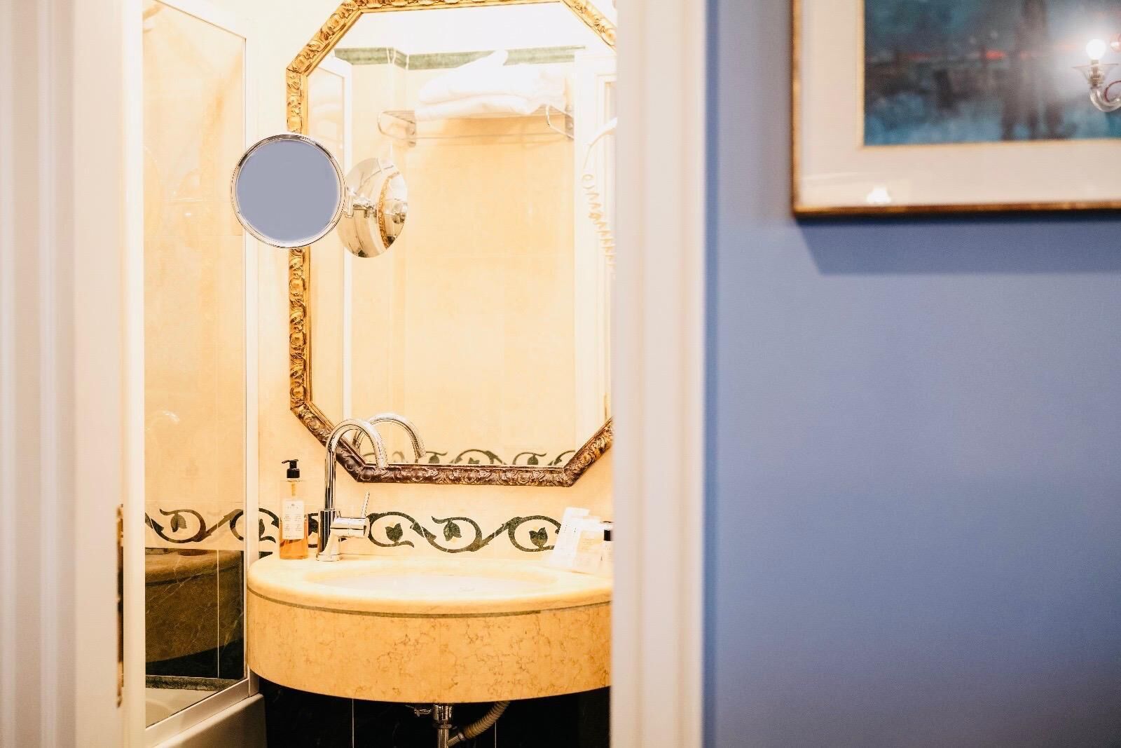 Ein Badezimmer mit Waschbecken, Spiegel und dekorativem Rahmen.